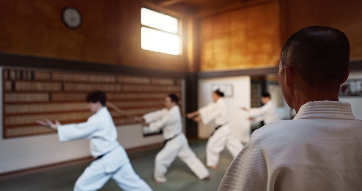 An instructor guiding a martial arts class in a traditional dojo